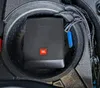 A compact subwoofer is placed in the spare tire well of a vehicle. Voir les images du produit