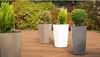 Four planters with plants on a wooden deck. Náhľad obrázku produktu