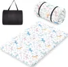 A rolled-up futon mattress with a unicorn pattern and a black carrying bag. Náhled obrázku produktu