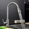 A modern kitchen faucet with water running into a sink, with decorative jars in the background. Náhľad obrázku produktu