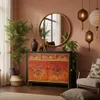 A room with a vintage-style sideboard, a mirror, plants, and decorative items. Produktbild-Vorschau
