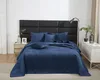 A bed with blue bedding and pillows, set against a black headboard. Produktbild-Vorschau