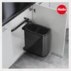 A pull-out trash bin system installed inside a kitchen cabinet. Voir les images du produit
