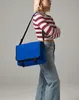 A woman is posing with a blue messenger bag. Anteprima dell’immagine prodotto