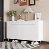 A white shoe cabinet with gold legs is shown in an entryway, with slippers placed underneath and a rug in front. Anteprima dell’immagine prodotto