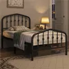 A bedroom scene with a black metal bed frame, bedding, and a nightstand with a lamp. Podgląd zdjęcia produktu