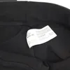 A close-up view of a clothing label inside a black garment. Produktbild-Vorschau