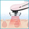 A close-up of a pink facial massage device emitting red light into a diagram of skin layers, with blue bubbles indicating a cleansing effect. Náhľad obrázku produktu