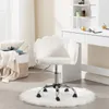 A white velvet office chair with a shell-shaped backrest is placed on a white fluffy rug in front of a white vanity table. Produktbild-Vorschau