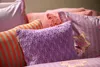 A close-up view of several decorative pillows with different patterns and colors. Produktbild-Vorschau
