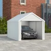 A white car is parked inside a white tent garage structure, with a brick building and trees in the background. Náhled obrázku produktu
