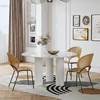 A modern dining room with a round white table and four chairs, set on a patterned rug. Produktbild-Vorschau