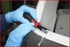 Hands wearing blue gloves using a tool to scrape something off a white surface. Podgląd zdjęcia produktu