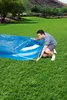 A man is setting up a blue pool cover on a grassy lawn. Produktbild-Vorschau