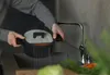 A person is rinsing a pot in a kitchen sink. Podgląd zdjęcia produktu