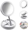 A collage of images showing a white makeup mirror with LED lights, its folded state, and a close-up of its base with makeup items. Náhľad obrázku produktu
