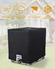 A black cover for a 1000L IBC water tank is shown outdoors in front of a blurred house. Produktbild-Vorschau