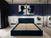 A modern bedroom with a dark blue upholstered bed frame as the central focus. Náhľad obrázku produktu