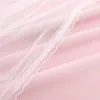 A close-up view of pink fabric with a white lace trim and a sheer white overlay. Náhľad obrázku produktu