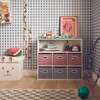 A child's room with a storage unit filled with toys and decorations. Anteprima dell’immagine prodotto