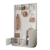 A white entryway organizer with a bench, shelves, and cabinets, featuring coats, bags, and shoes. Produktbild-Vorschau