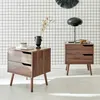 Two wooden nightstands are placed in front of a grid-patterned wall. Produktbild-Vorschau