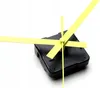 A close-up shot of a clock movement with yellow hands against a white background. Produktbild-Vorschau