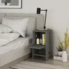A bedside table next to a bed with a lamp and books on it. Anteprima dell’immagine prodotto