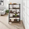 A bookshelf filled with decorative items and books, placed in a living room setting next to a sofa. Produktbild-Vorschau