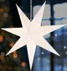 A white paper star lantern with small white dots is hanging in front of a window with blurred lights in the background. Produktbild-Vorschau