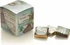 A cube-shaped box of chocolates with three individual chocolates in the foreground. Produktbild-Vorschau
