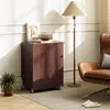 A wooden cabinet with a door and wheels, next to a brown leather chair and a floor lamp, with a plant on the left. Anteprima dell’immagine prodotto