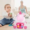 A baby is playing with a toy unicorn and blocks on the floor, while a woman practices yoga in the background. Anteprima dell’immagine prodotto