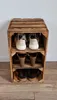 A wooden shoe rack made from crates, filled with shoes. Produktbild-Vorschau