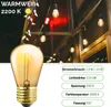 A close-up of a vintage-style LED light bulb with a background of other illuminated bulbs. Produktbild-Vorschau