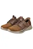 A pair of brown SKECHERS SLIP-INS SLADE - ZACHARY shoes are shown from a side-angle on a white background. Voir les images du produit