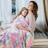A mother and daughter are cuddling under a colorful unicorn-themed blanket. Náhľad obrázku produktu