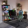 A gaming setup with a desk, chair, and shelves in a room. Produktbild-Vorschau