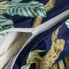 A close-up of a duvet cover with a zipper partially open, showing a tropical leaf and wild cat pattern. Náhled obrázku produktu
