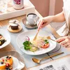 A person is eating a meal at a table with a set of dishes. Náhled obrázku produktu