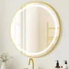 A round LED bathroom mirror with a gold metal frame is shown mounted on a wall above a sink. Podgląd zdjęcia produktu