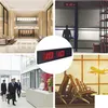 Collage of four images showing a digital clock in different settings: a modern lobby, a warehouse, an office reception, and an airport waiting area. Podgląd zdjęcia produktu