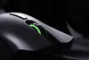 A close-up shot of a black gaming mouse with green LED lighting. Produktbild-Vorschau