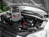 A jump starter pack is connected to a car battery under the hood. Anteprima dell’immagine prodotto
