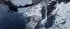 A bird-like creature flies over a snowy mountain pass with people on a wooden bridge. Náhľad obrázku produktu
