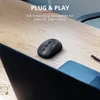 A black wireless mouse is placed on a wooden desk next to a laptop. Produktbild-Vorschau