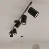 A black track lighting fixture with six adjustable spotlights mounted on a white ceiling. Podgląd zdjęcia produktu