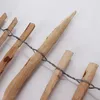 A close-up view of a wooden fence made of pointed stakes bound together with wire. Produktbild-Vorschau