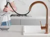 A person is filling a glass pitcher with water from a kitchen faucet. Produktbild-Vorschau