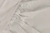 A close-up view of a beige fitted sheet, showing the elasticized edge and fabric texture. Náhled obrázku produktu